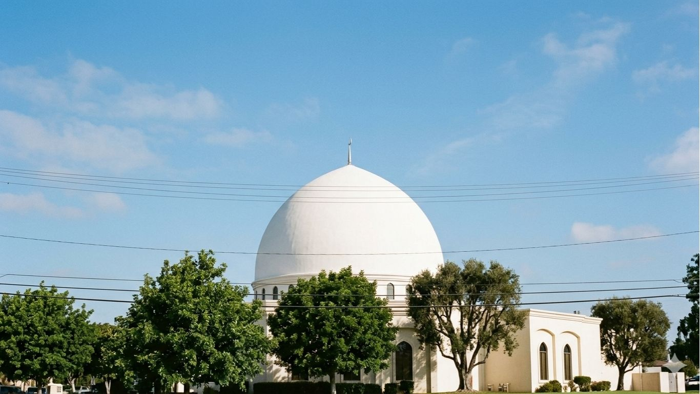 A quiet white-domed sacred space in San Diego beneath a clear blue sky, representing community presence, dignity, and the room that remains after violence.